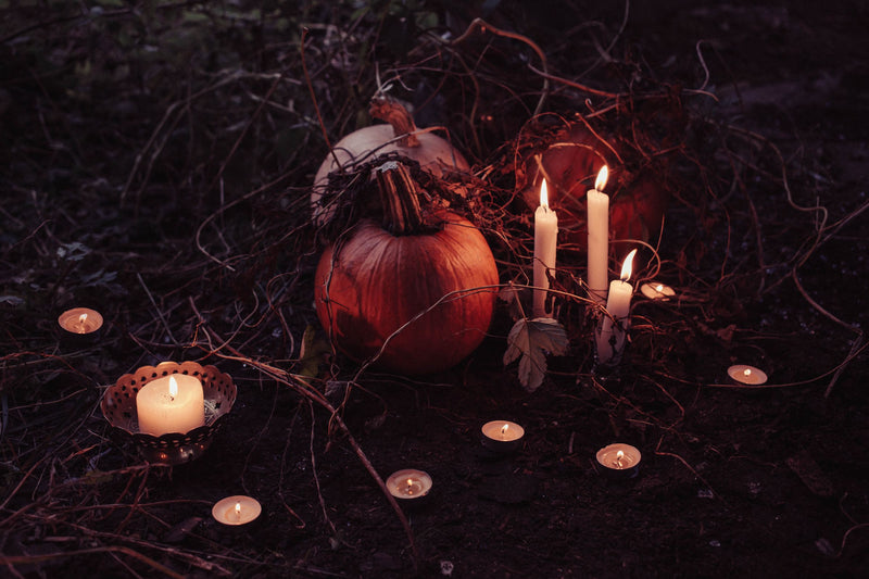 Citrouille et bougies allumées dans la nuit pour un rituel de Samhain